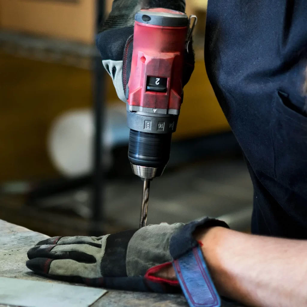 Arbeiterin beim benutzen der Bohrmaschine